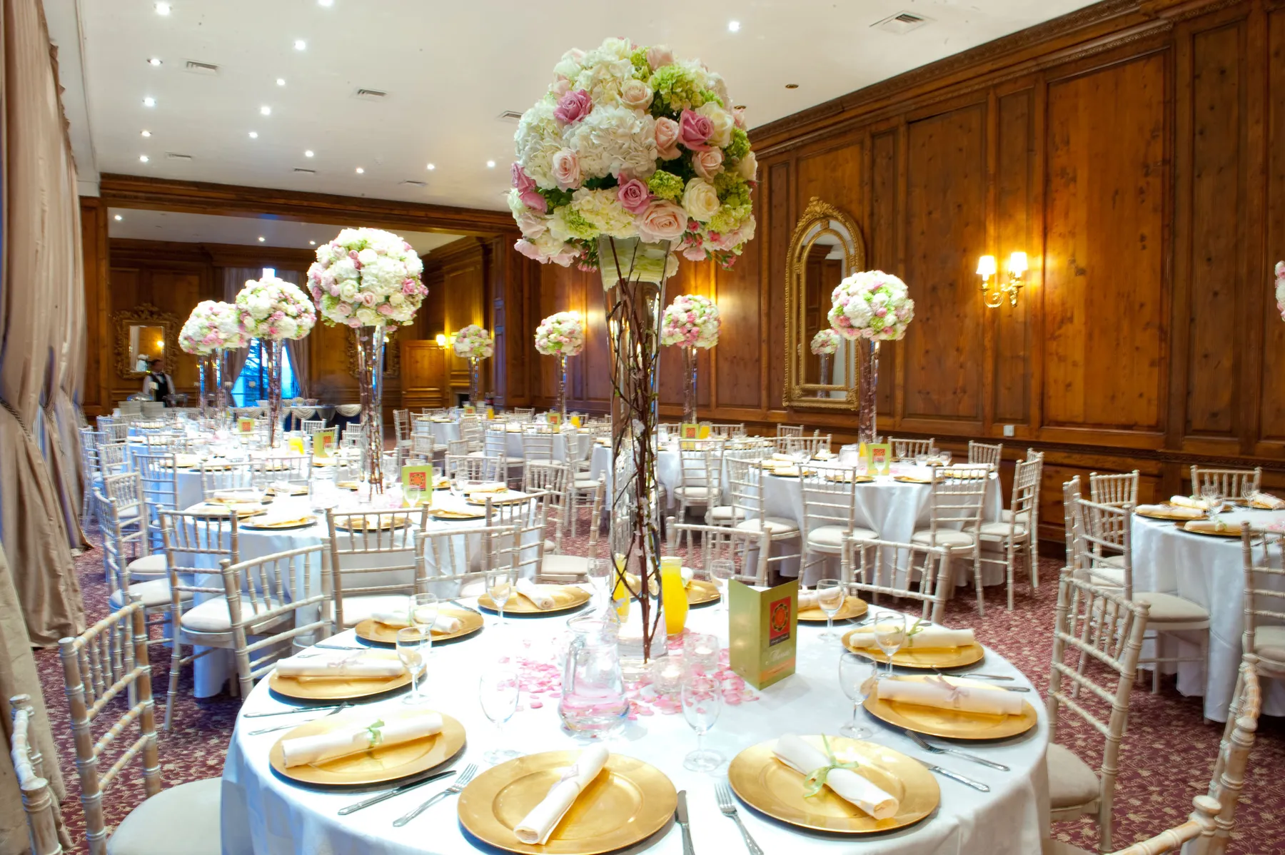 A wood-panelled ballroom set with tall white florals