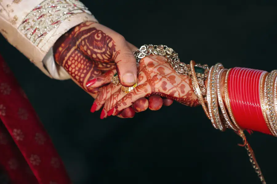 Two hands with intricate henna patterns