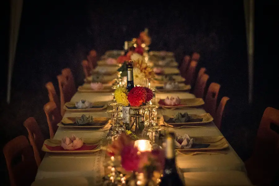 A long dinner table set with flowers and candles